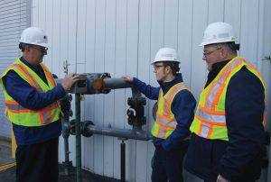 UGI employees Larry Sipsky, Tim Adams, and Joe Bauman inspect the upgraded gas metering facilities.